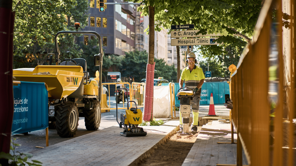 Operaio con piastra vibrante e dumper.